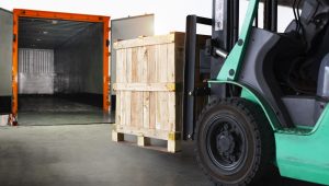 forklift-tractor-loading-wooden-crate-boxes-into-cargo-container-shipping-trucks-cargo-shipment-1-scaled.jpg