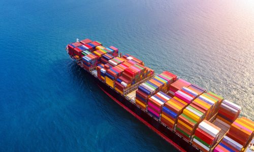 Container shipping services in the United States Aerial view of container cargo ship in sea.